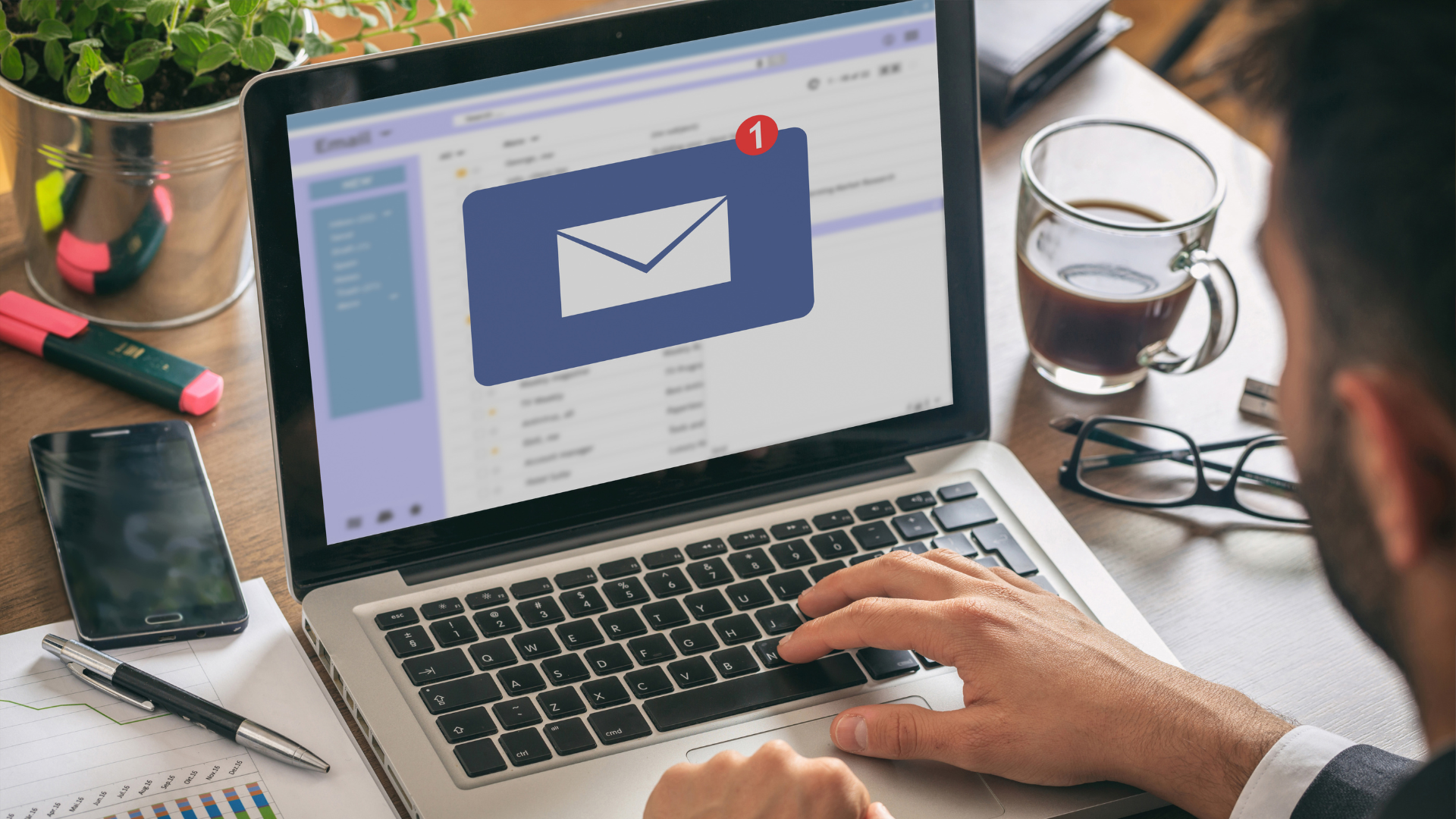 Pantalla de laptop mostrando nueva notificación de correo electrónico en un entorno de oficina